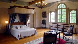 A bedroom with a four-poster bed, a chandelier, a bench, and large windows. - Château de Bonnemare (Radepont)