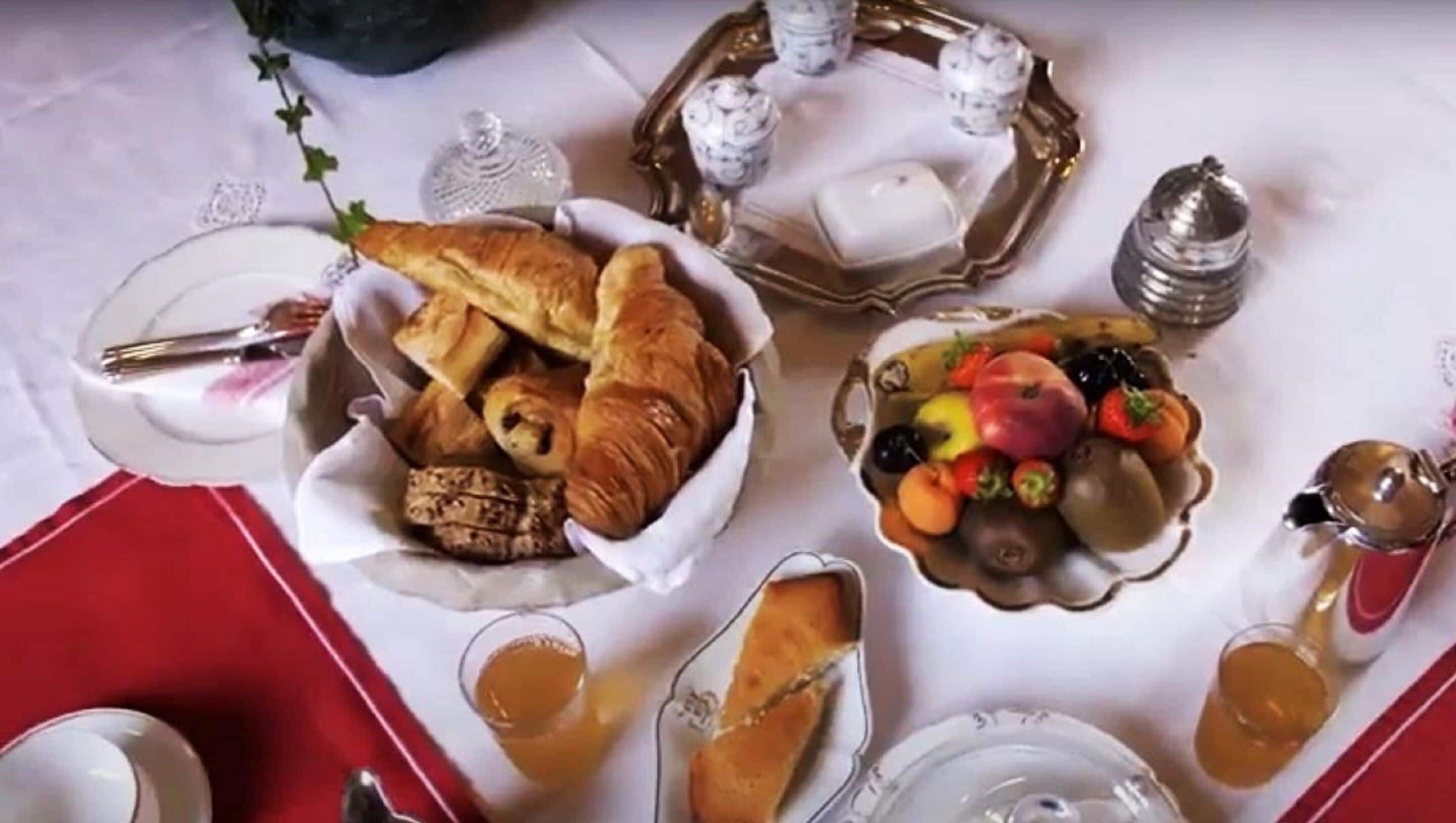 A table set with various food items including pastries, fruits, and glasses of a golden beverage, likely for a breakfast or brunch setting.