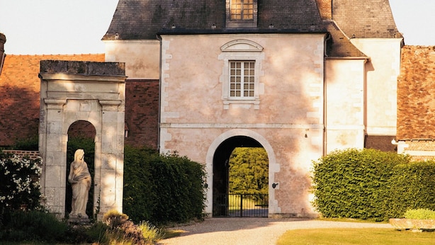 A historic building with a central archway, a statue, and a well-maintained lawn. - Château de Bonnemare (Radepont)
