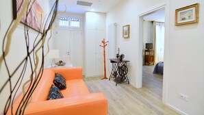 A bright living room with a sofa, a sewing machine, and a window with bars. - Ca' Etta (Venice)