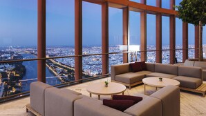 A modern lounge with large windows offering a city view. - Eurostars Torre Sevilla (Seville)
