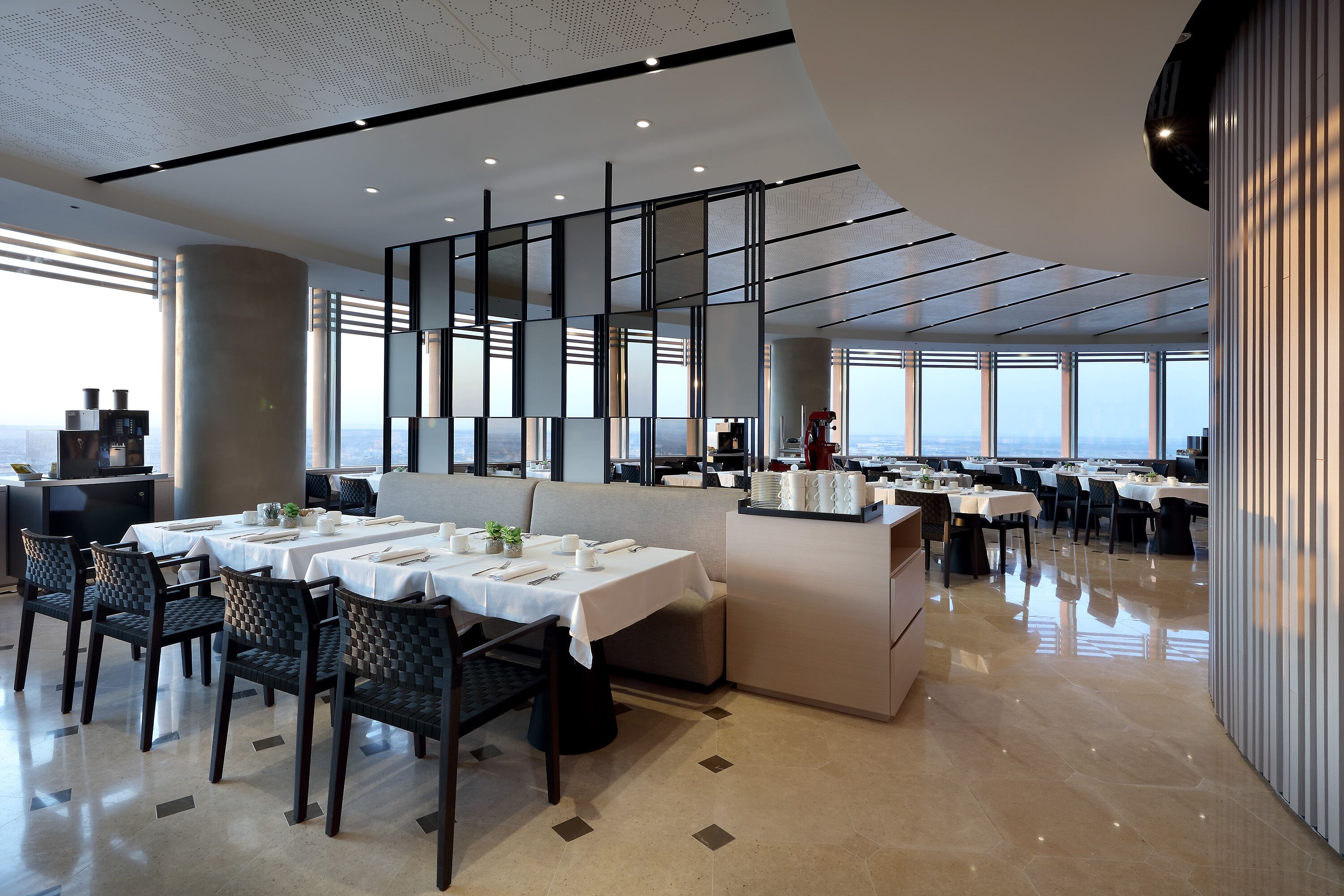 Un comedor moderno con techos altos, ventanas amplias y una isla central.