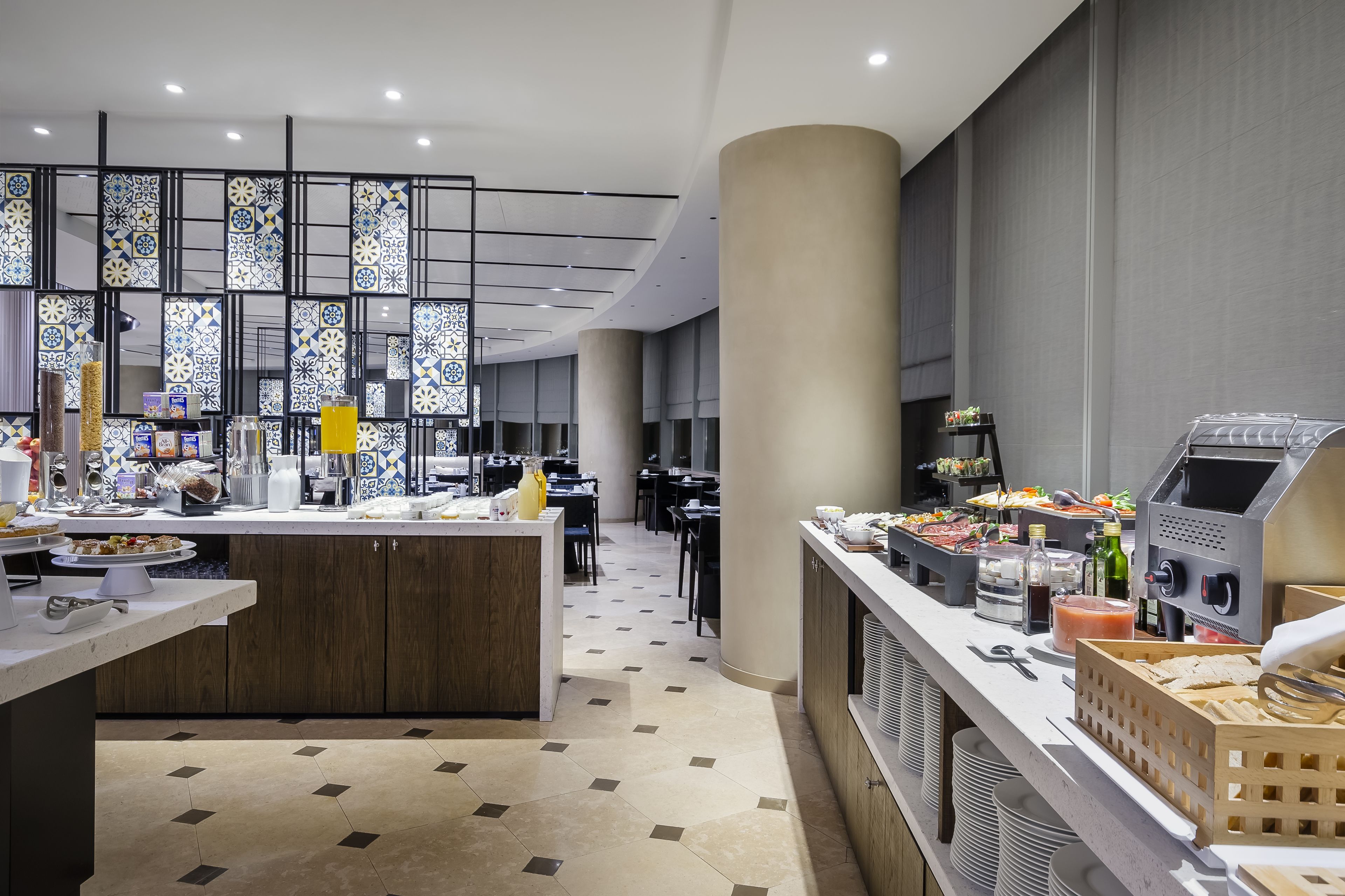 Un hall d’hôtel moderne avec un îlot central, un espace salon et un buffet.