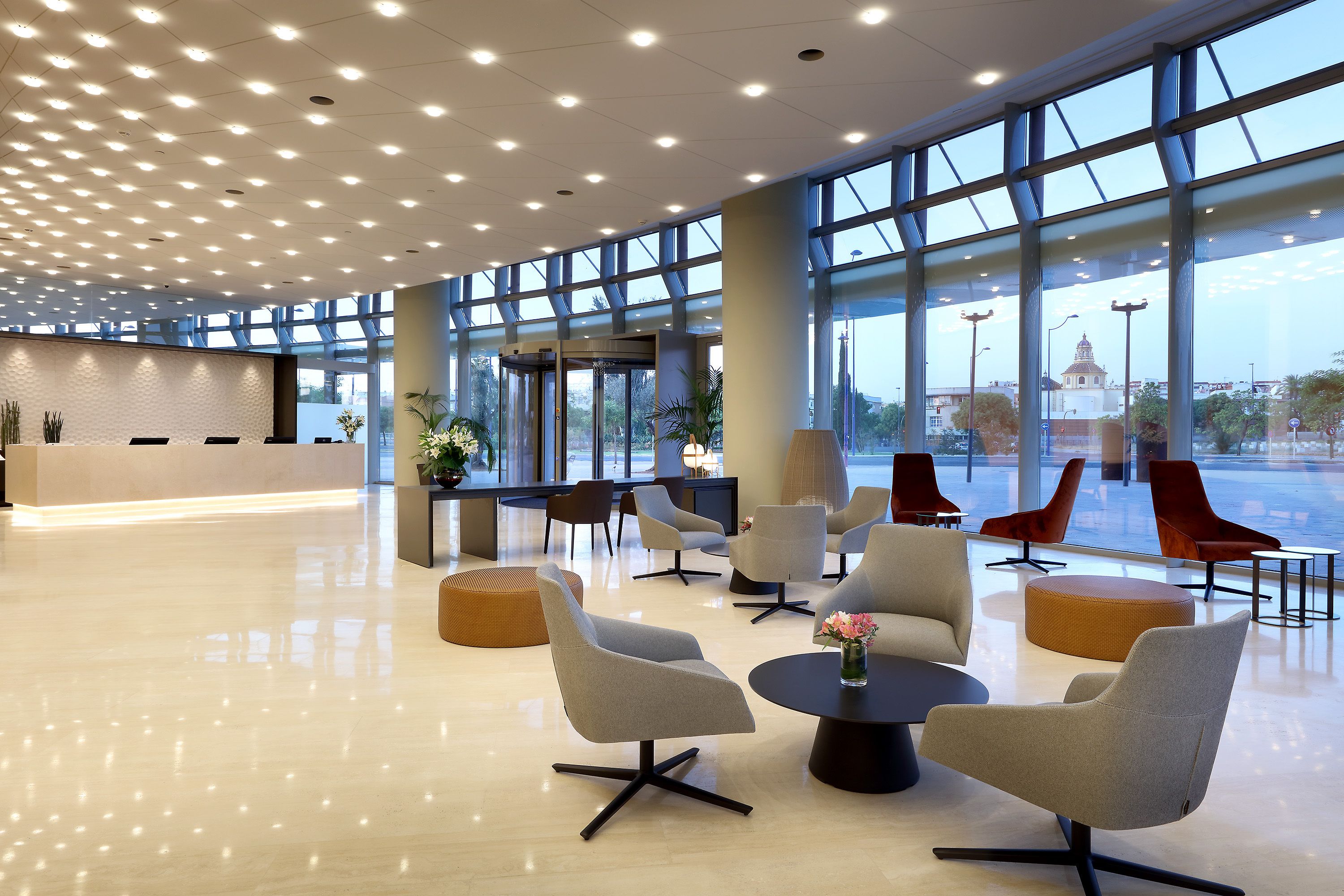 A spacious lobby with modern seating, large windows, and a reception area.