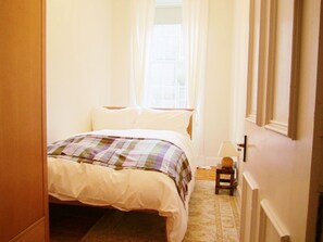 A bedroom with a bed, a nightstand, a lamp, and a window with curtains. - Edinburgh City Retreat Apartments (Edinburgh)
