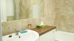 A bathroom with a sink, mirror, and shower. - Edinburgh City Retreat Apartments (Edinburgh)