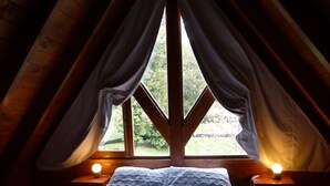 A cozy bedroom with a bed, two bedside lamps, and a window with curtains. - Tierra Sureña (San Carlos de Bariloche)