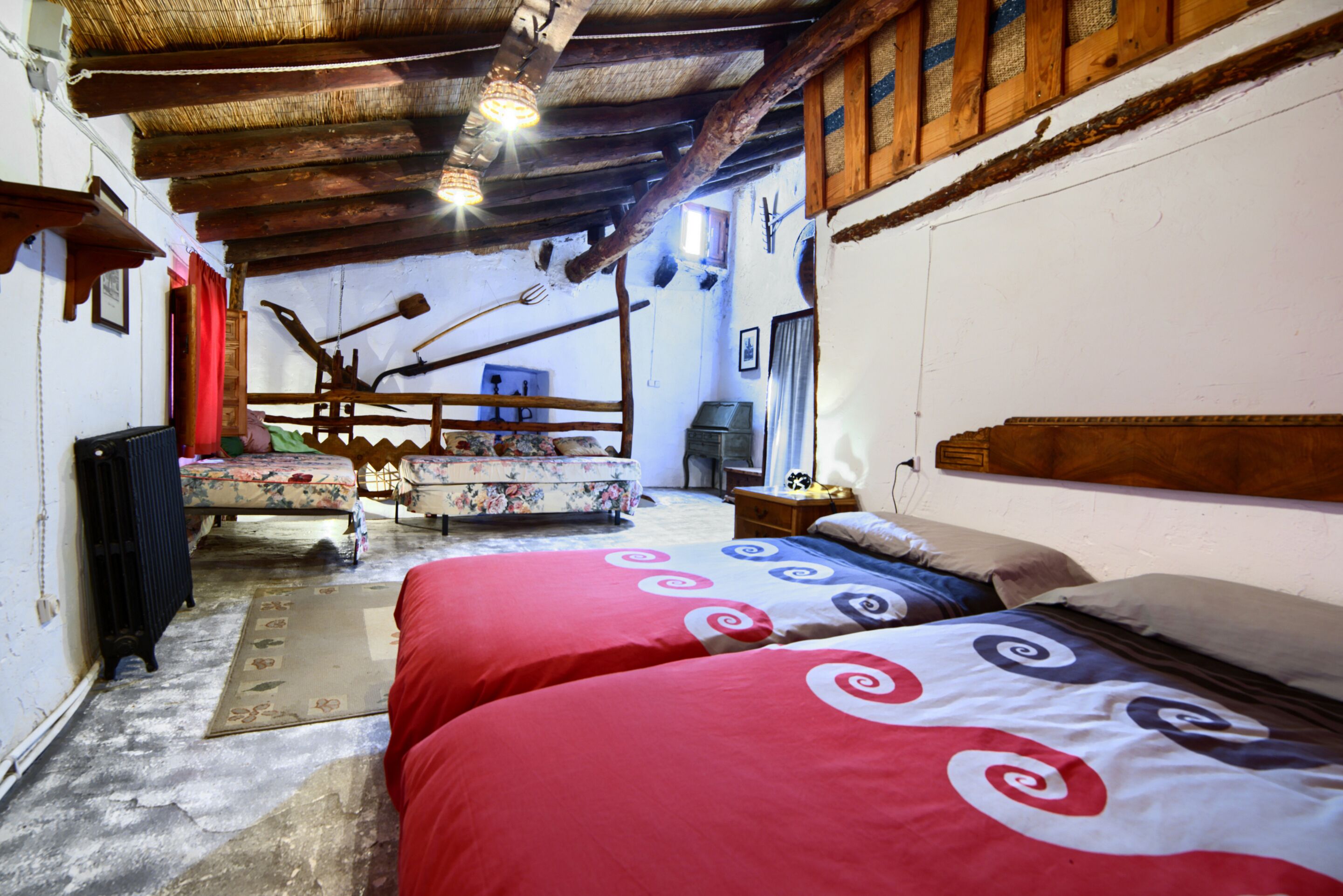 Une chambre rustique avec deux lits, des poutres en bois et un décor traditionnel.