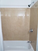 Bañera con ducha, secador de pelo, toallas
