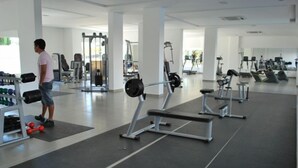 Un gimnasio con equipo de levantamiento de pesas, cintas de correr y máquinas de ejercicio.