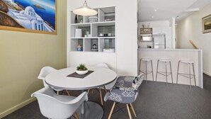 A modern kitchen with white cabinets, a microwave, and a sink. - Lorne Beachfront Accommodation (Lorne)