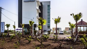A modern building with a sign reading "AMANTOV". - Amantov Pension (Seogwipo)