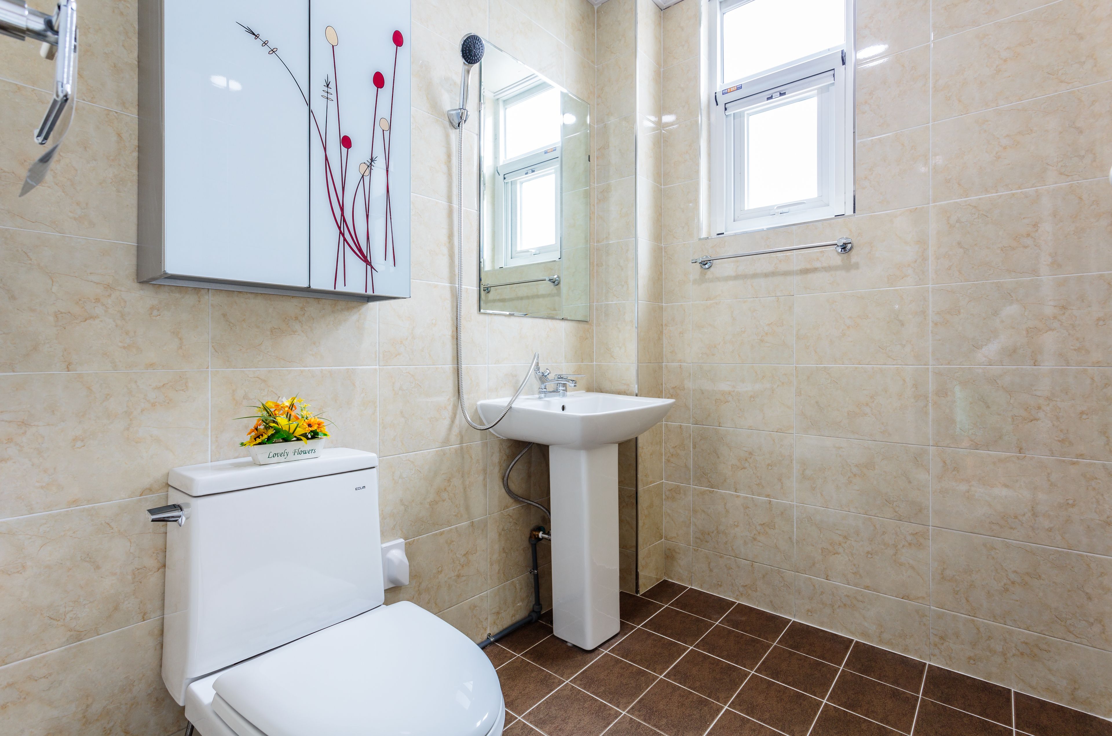 A bathroom with a toilet, sink, and mirror.