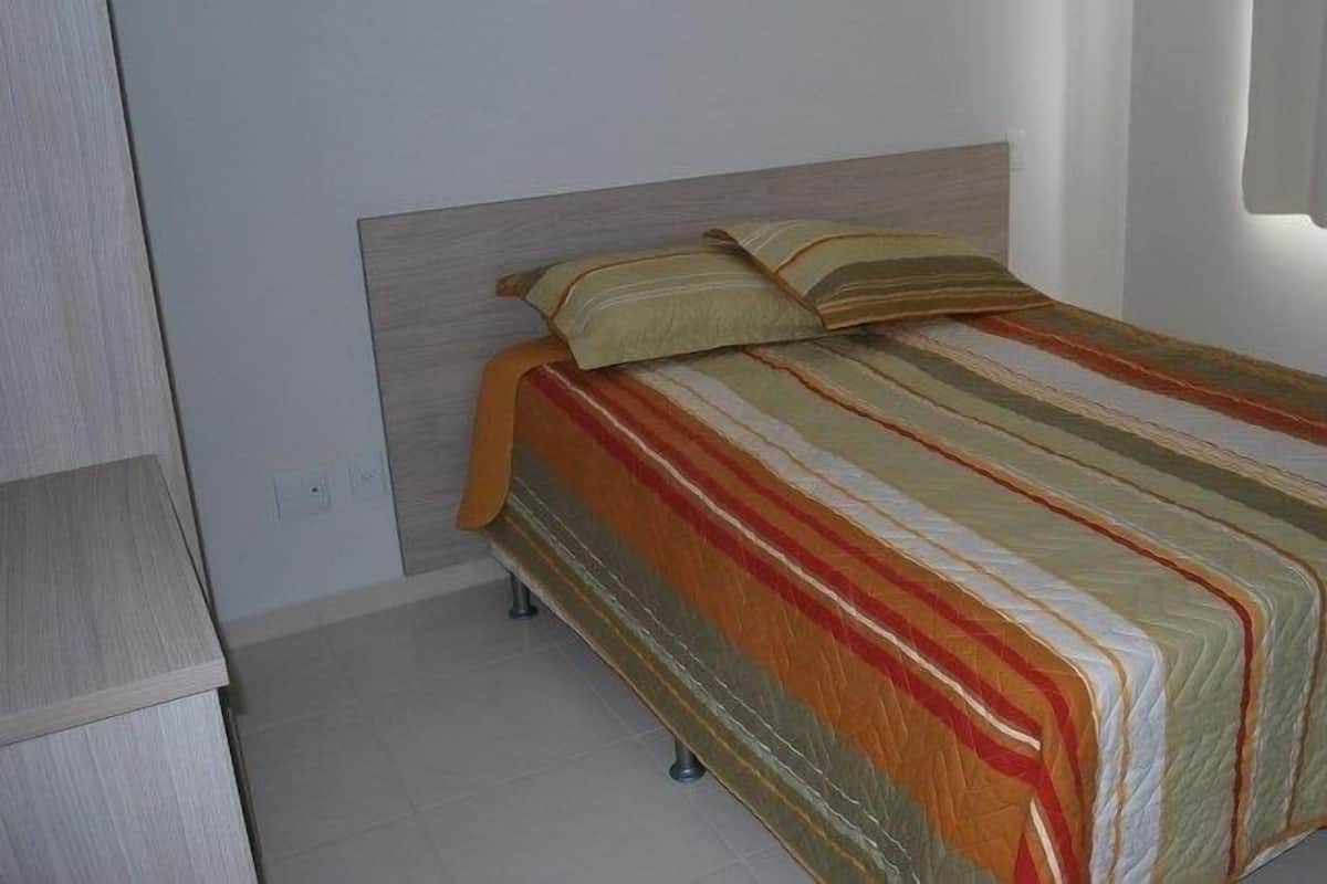 Una camera da letto con un letto, una testiera e un armadio.