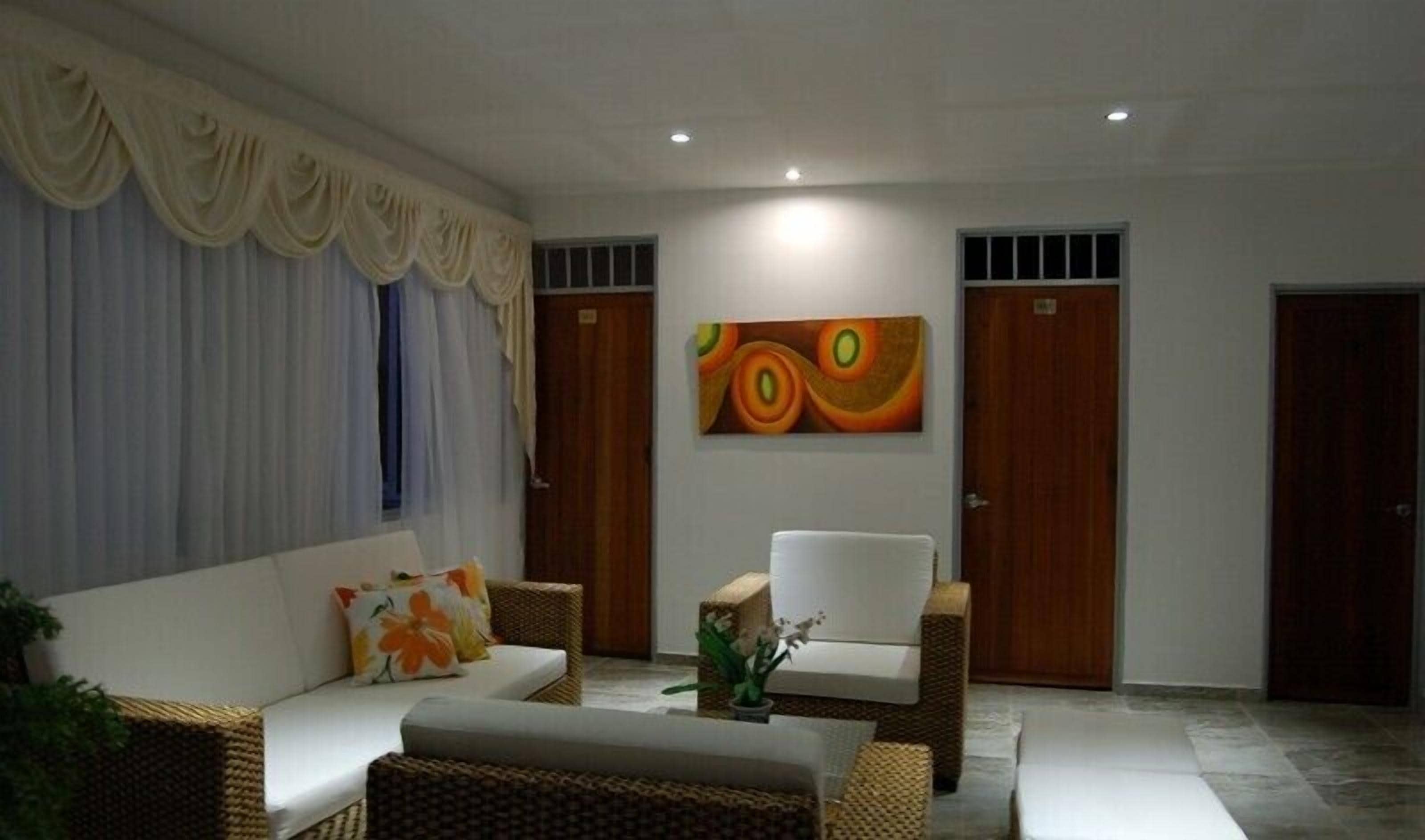 A modern living room with a sofa, armchairs, and a decorative painting.