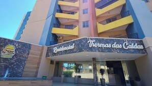 A hotel entrance with a sign reading "Residencial Thomas das Caldas". - Thermas das Caldas - Achei Férias (Caldas Novas)