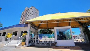 A building with a covered entrance, a staircase, and a tall adjacent building.