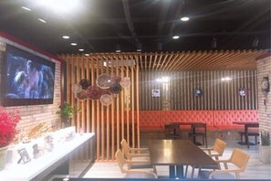 A conference room with a long table, chairs, a TV screen, and a decorative wall panel. - Prime Tourist Hotel (Busan)