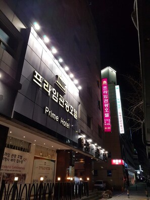 Un hotel con un cartello ben visibile per 'Prime Hotel' e un cartello verticale con testo in coreano.