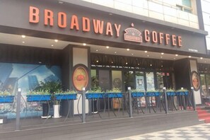 A storefront with the sign 'Broadway Coffee' and a large mural on the wall. - Prime Tourist Hotel (Busan)