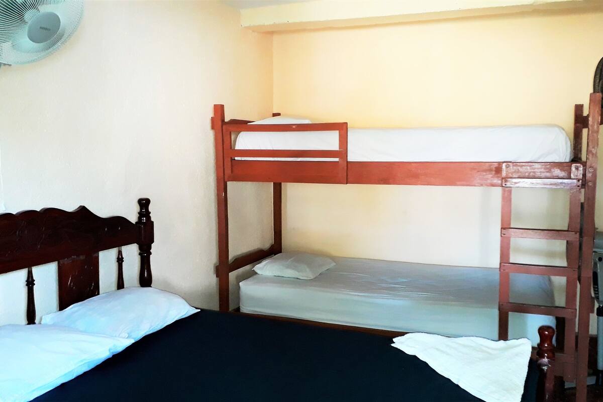 Una cama litera con cabecera de madera y colchón en la parte superior.