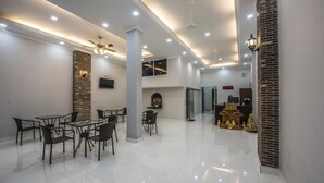 Amplia habitación, bien iluminada, con zona de comedor, chimenea y mostrador de recepción.