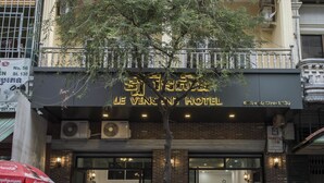 Un hotel con un letrero que dice "Le Vient Hotel" y un domicilio visible.