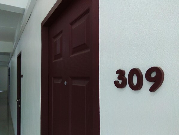 Eine Tür mit der Nummer 309 an einer weißen Wand.