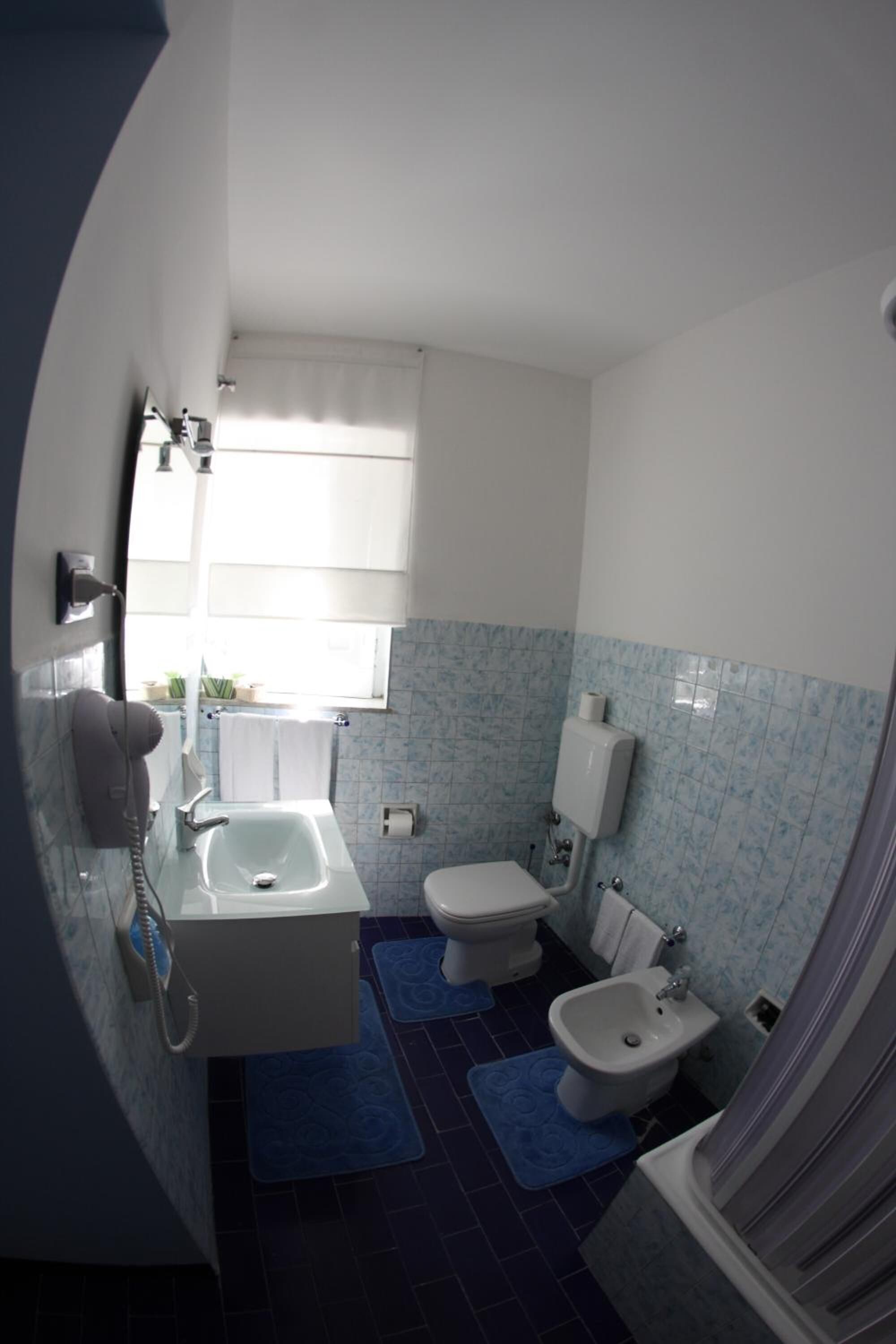 A bathroom with a sink, toilet, bidet, and bathtub.