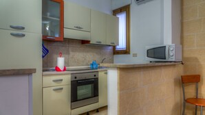 A compact kitchen with a built-in oven, a microwave, and a window above the sink. - Aquarium Residence (Manduria)
