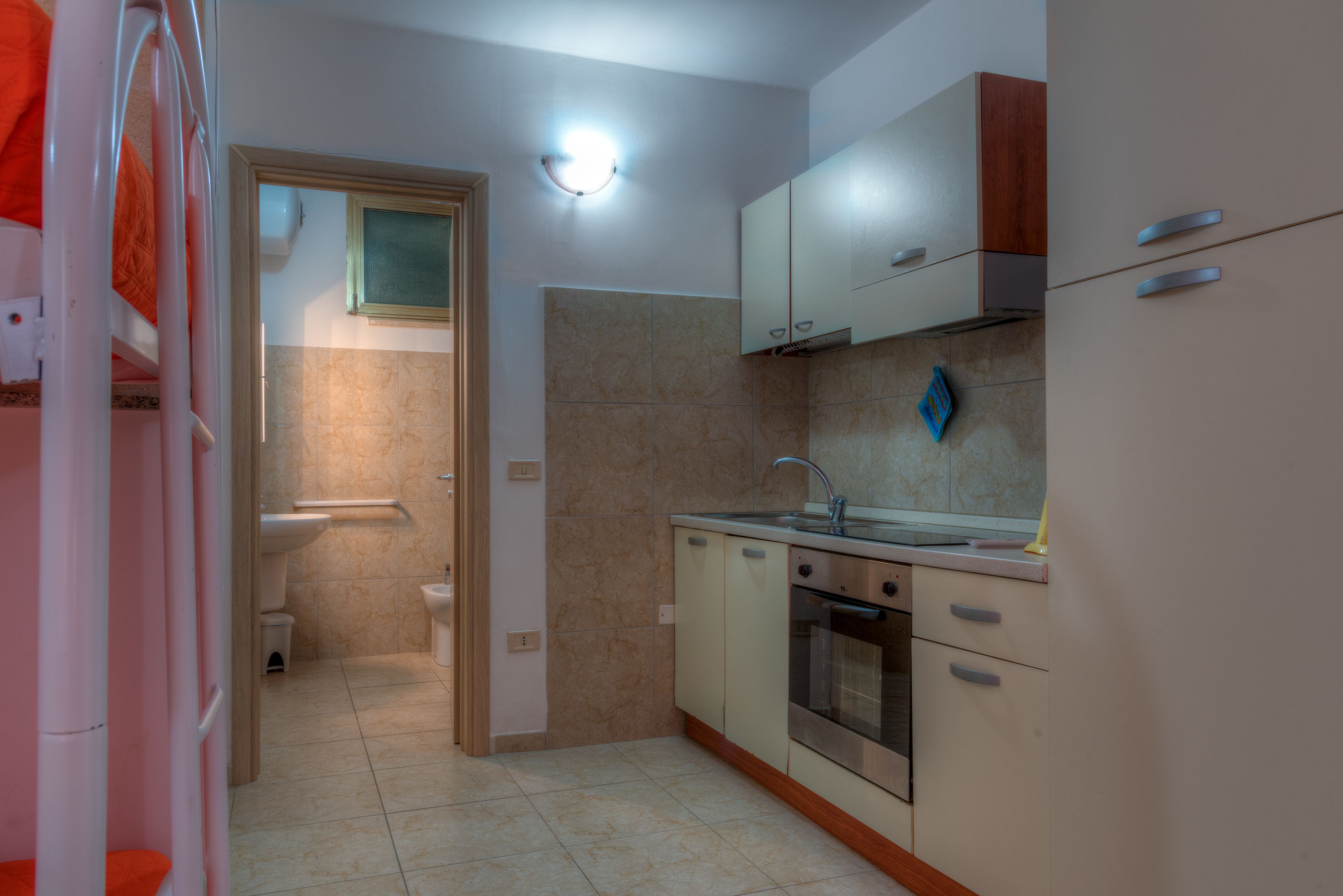 A compact kitchen with a sink, oven, and cabinets.