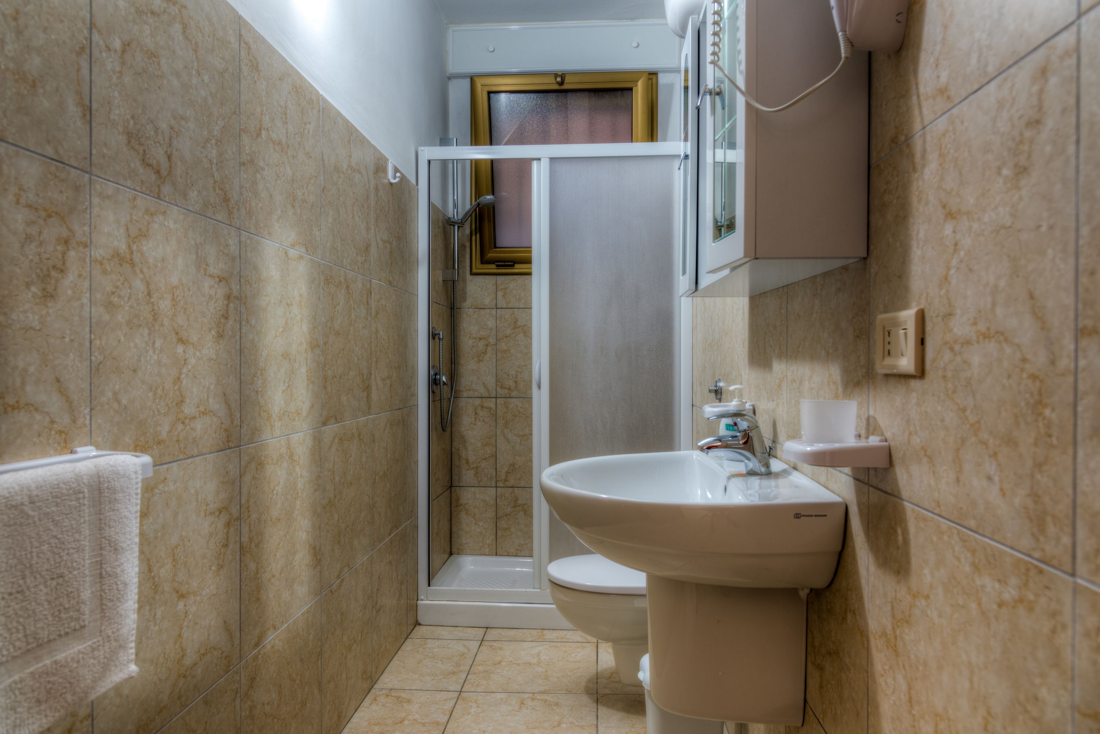 A bathroom with a shower, toilet, and sink.