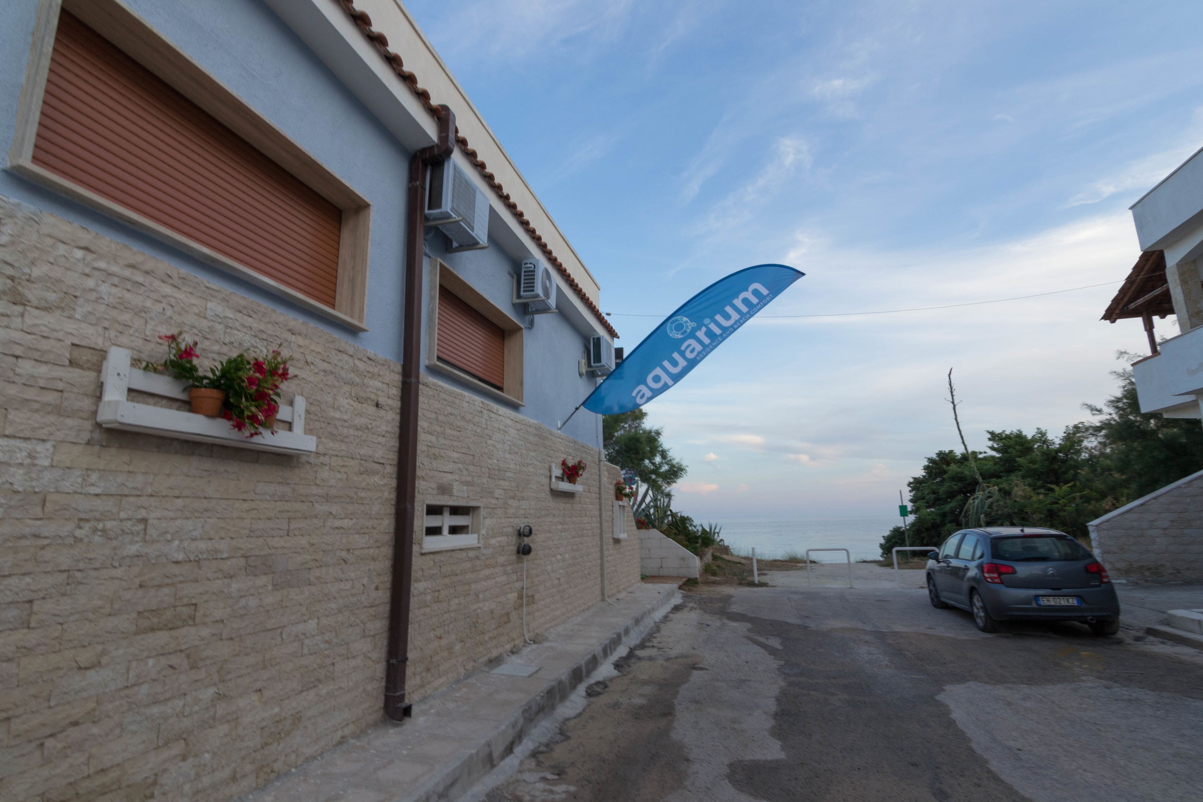 Vista de la calle con un edificio que dice 'acuario' y un coche aparcado.