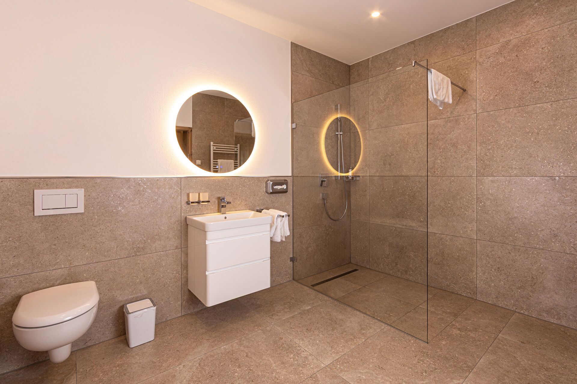 A modern bathroom with a toilet, sink, and shower.