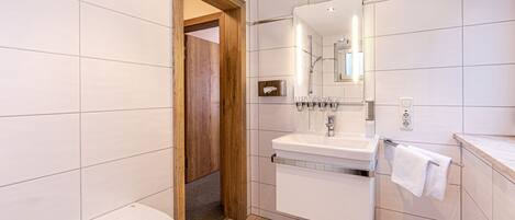 A modern bathroom with a bathtub, a sink, and a mirror.