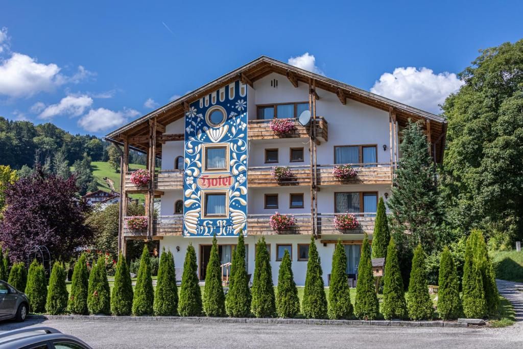 A multi-story hotel with balconies, a prominent decorative facade, and a well-maintained garden.