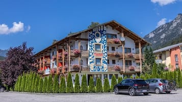 A hotel with multiple balconies, a prominent vertical sign, and a mountainous backdrop.