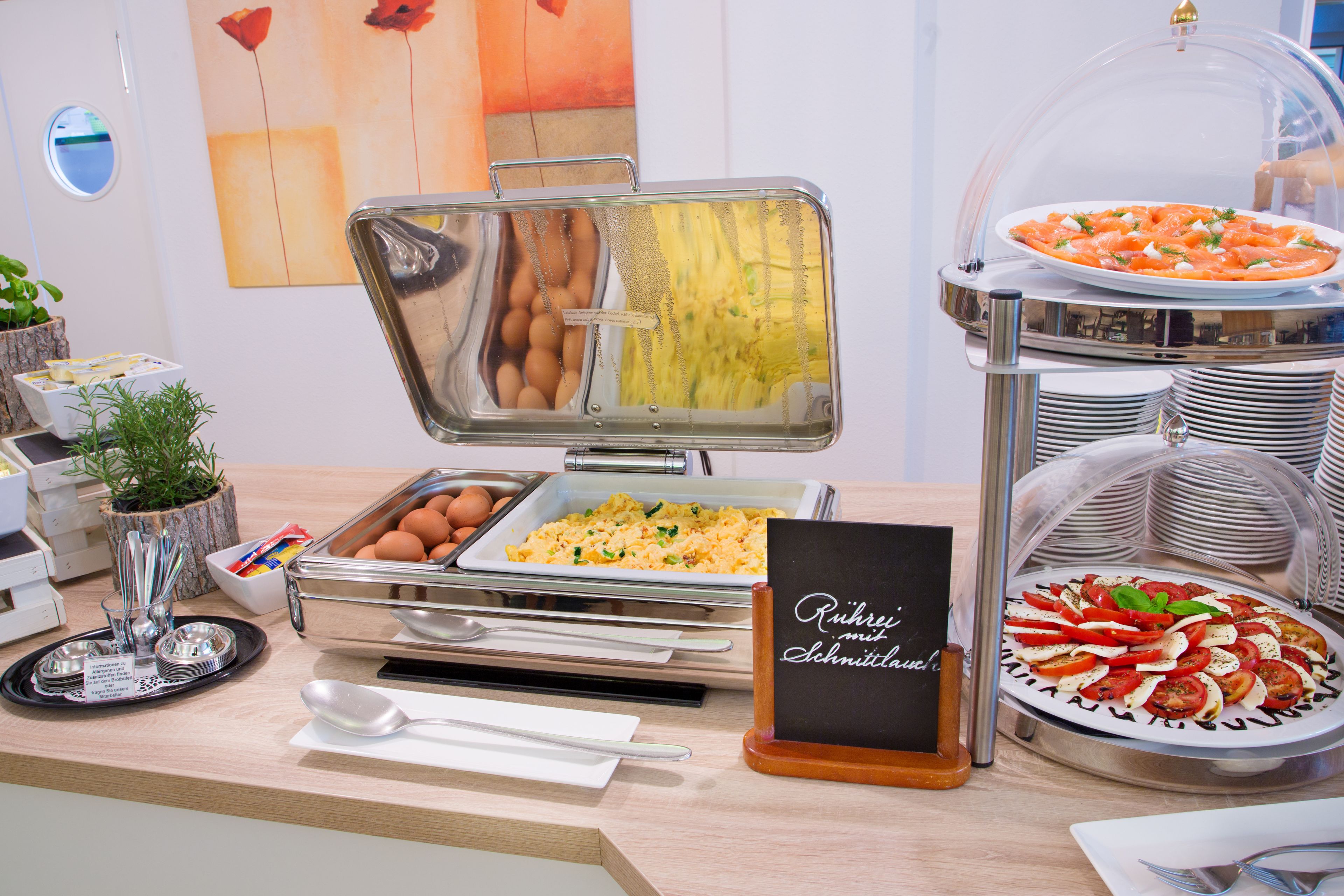 Ein Buffet mit verschiedenen Speisen, darunter Eier, Rühreier und Pizza.