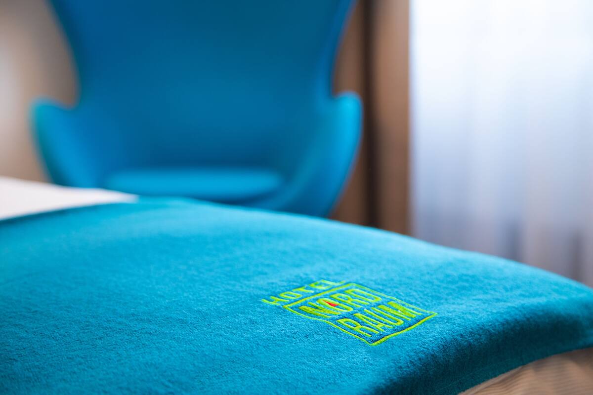 A blue chair with a logo on the backrest.