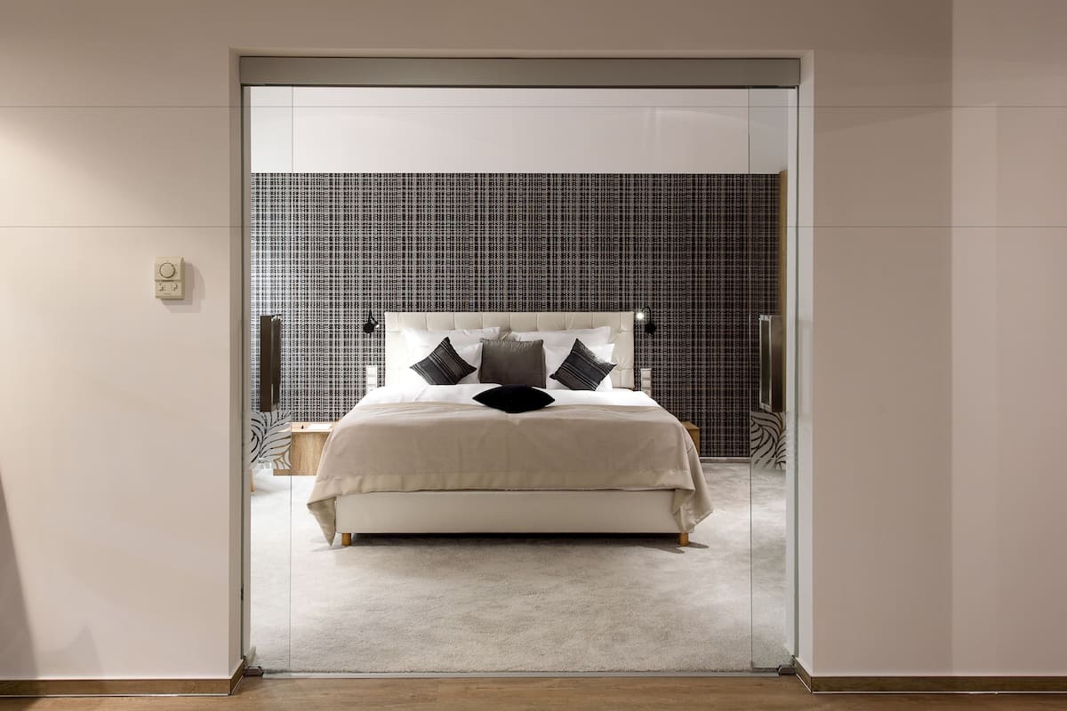 Ein Schlafzimmer mit einem Bett, einem Nachttisch und einer Wand mit Rautenmuster.