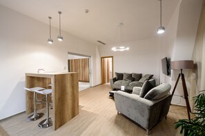 Suite Grand, 2 habitaciones, para no fumadores | Área de sala de estar | Televisión LCD de 50 pulgadas con canales por cable y Smart TV 