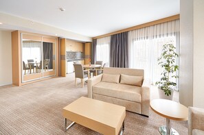 Suite, 1 très grand lit et 1 canapé-lit, balcon, en coin | Aire de séjour | Téléviseur ACL de 36 po avec télévision par satellite, téléviseur
