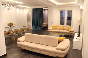 Suite superior, 4 habitaciones, balcón | Zona de estar | Una televisión de pantalla plana