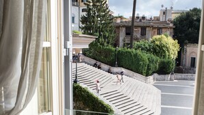 Une table à manger offrant une vue sur le paysage urbain, avec notamment un palmier et des immeubles.