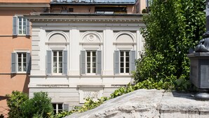 Un bâtiment de style classique, doté de fenêtres en arc de cercle et d’un balcon.