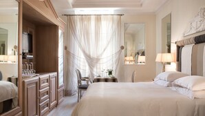 Une chambre d’hôtel avec un grand lit, un bureau avec une lampe, une chaise et une armoire.