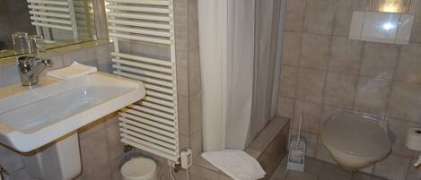 A bathroom with a sink, toilet, and shower.