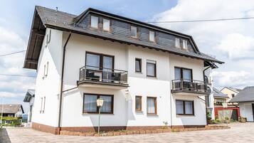 Un edificio residenziale di due piani con tetto piatto, diverse finestre e balconi.