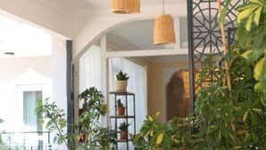 A balcony with wicker pendant lights, potted plants, and a decorative metal partition. - Taner Otel (Fethiye)