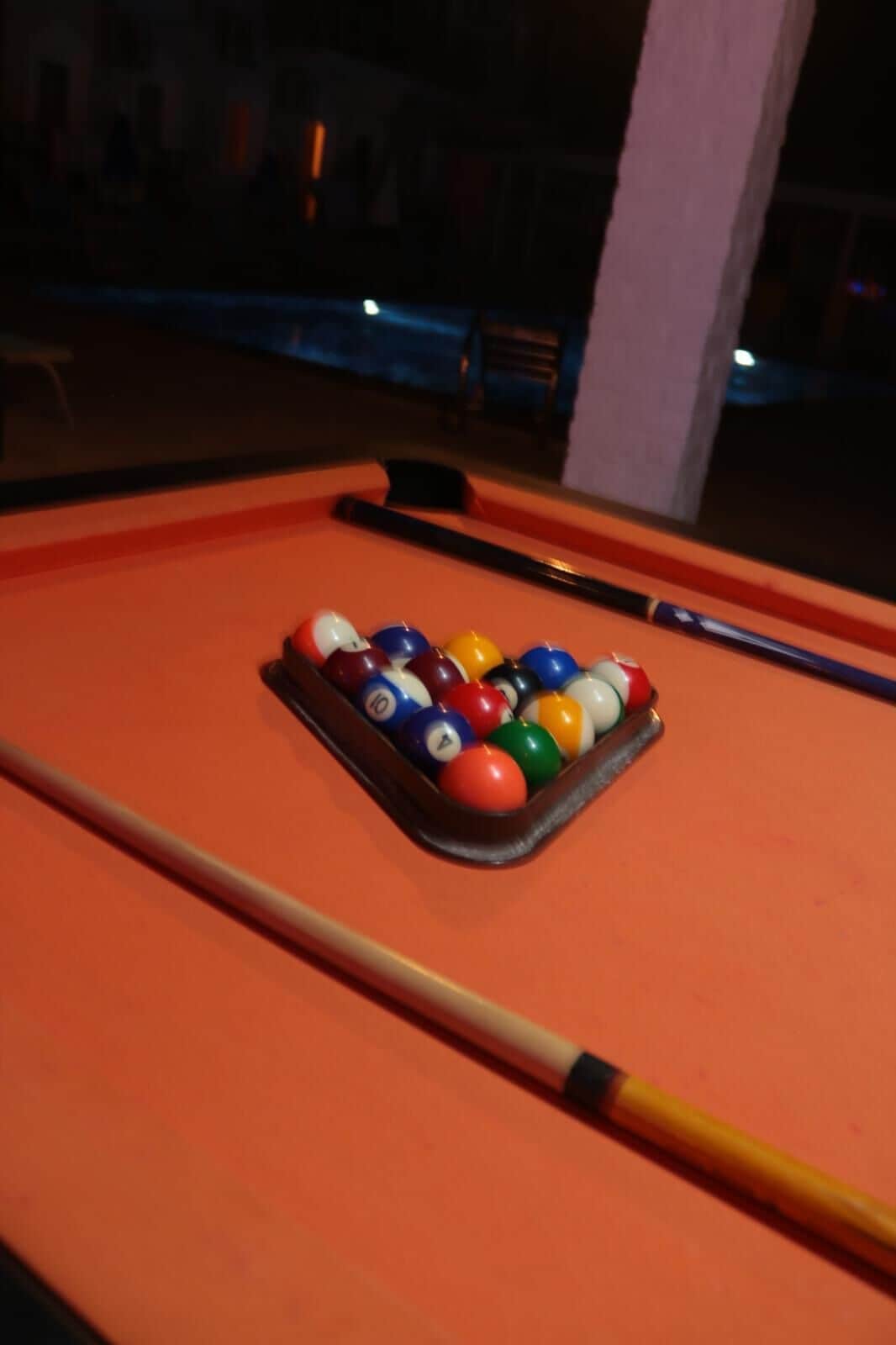 Een biljart met een set biljar balls en een keu.